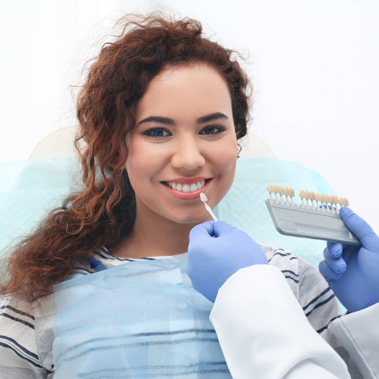 https://kokuasmiles.tradebuilderinc.comThe young lady is consulting with the dentist to find the perfect veneers | Kokua Smile